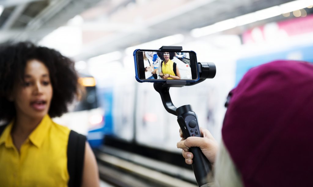 mulher jovem adulta e micro influenciadora no metro gravando um vídeo para suas redes sociais